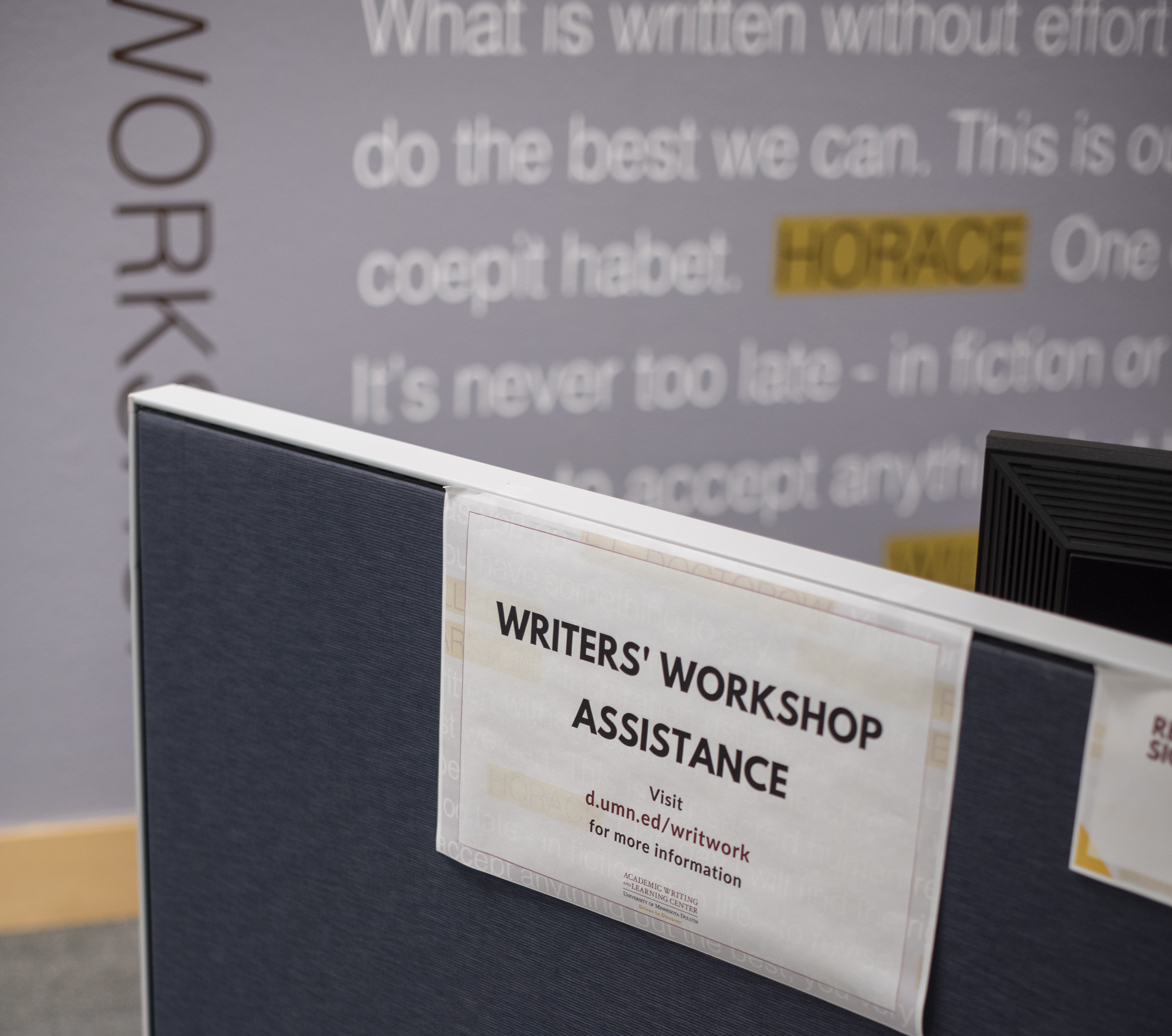 a sign advertising "writers' workshop assistance"